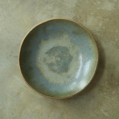 a small blue bowl sitting on top of a white countertop next to a wall