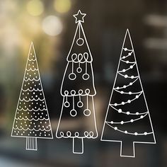 three hand drawn christmas trees on a window