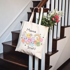 a tote bag sitting on top of a stair case next to a bouquet of flowers