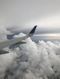 an airplane wing flying above the clouds