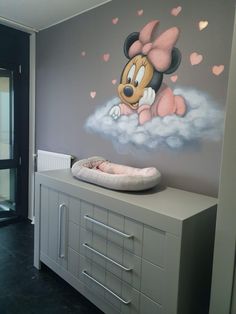 a baby's room with a mickey mouse mural on the wall