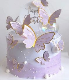 a white cake with purple butterflies on it