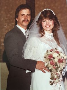 a bride and groom pose for a wedding photo