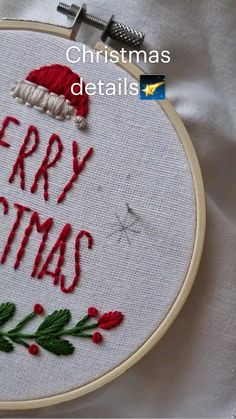 a christmas decoration with the words merry christmas written in red and green on white fabric