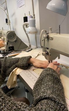 the woman is working on her sewing machine