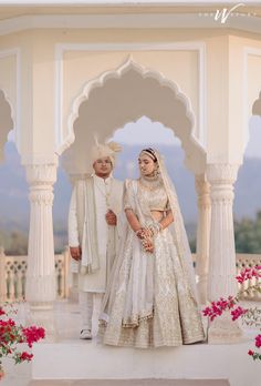 two people standing in front of a white structure