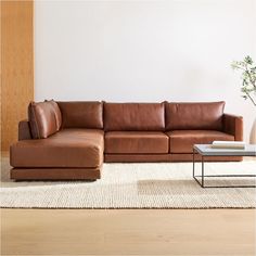 a brown leather couch sitting on top of a white rug