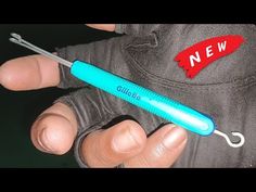 a person holding a blue toothbrush in their hand with a red sticker on it