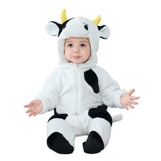 a baby wearing a cow costume sitting on the ground