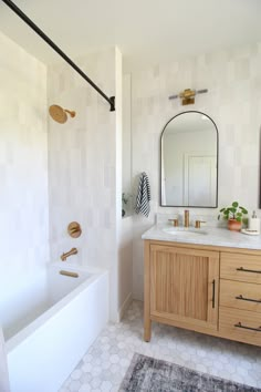 a bathroom with a sink, mirror and bathtub