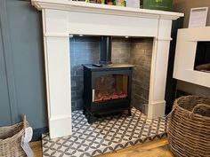 a fireplace with a black and white tile floor next to a basket on the floor