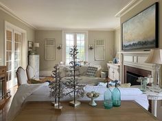 a living room filled with furniture and a christmas tree in front of a fire place