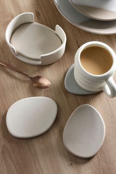 there are three cups and spoons on the table next to each other with saucers