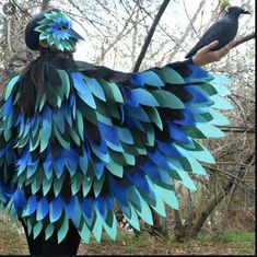 a woman wearing a blue and green bird costume