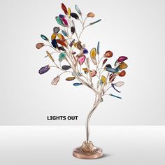 a metal tree with colorful glass leaves on it's branches and the words lights out