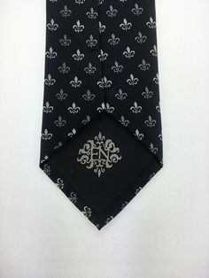 "Perfect for a black tie wedding. This black tie with Fleur De Lis design is a classic must have tie. Available as a extra long neck tie. Handmade from 100% silk, this special collection features a .75\" Eds Neckties logo at the bottom right front corner of every tie and a larger logo located on the tipping (Back of the tie). The label features the collection name (Nathaniel Alexandria) Named after my son Nathaniel and my daughter Alexandria. Expertly hand-made from 100% silk you can select your Classic Fitted Silver Suit And Tie Accessories, Silver Standard Tie For Black Tie Events, Classic Black Tie For Wedding, Black Tuxedo Ties For Wedding, Elegant Black Ties For Groom, Elegant Silver Suit And Tie Accessories For Party, Elegant Black Tuxedo For Black Tie, Elegant Tie Accessories For Black-tie Events, Fitted Tuxedo With Ties For Black-tie Events