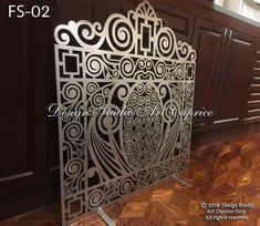 an ornate metal screen in the corner of a room with wood flooring and walls