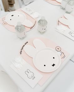 the table is set with bunny themed plates and place mats