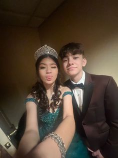 a man in a tuxedo poses for a photo with a young woman wearing a tiara