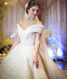 a woman in a white wedding dress is smiling at the camera with her hand on her hip