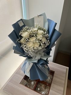 a bouquet of flowers sitting on top of a table next to a card and window