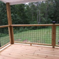 a wooden deck with metal railing and wood posts