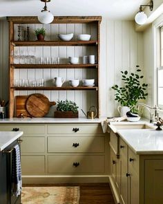 the kitchen is clean and ready to be used for cooking or baking, with dishes on shelving above the sink