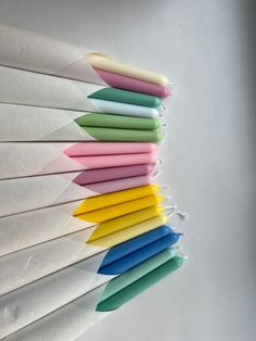 several different colored pens are lined up in a row on top of each other,