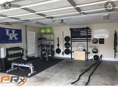 a garage gym with equipment and an american flag hanging on the wall