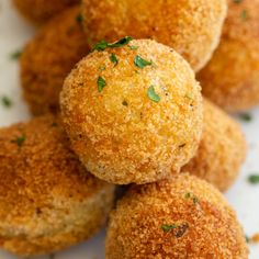 several small balls of food on a plate with parsley sprinkled on top