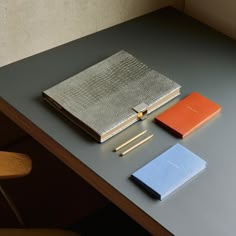 an assortment of notebooks and pens on a table