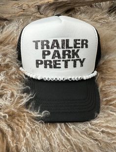 a black and white trucker hat with the words trailer park pretty printed on it