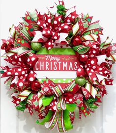 a red and green christmas wreath on a door