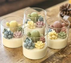 four small glass cups filled with different types of succulents and cacti