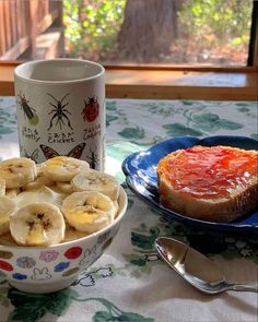 there is a bowl of bananas and bread on the table