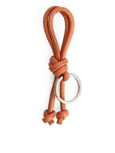 an orange leather keychain with two rings attached to it and a ring on the end