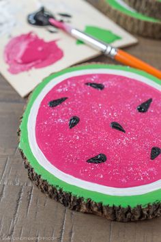 two slices of watermelon are sitting on the table next to some markers and pencils