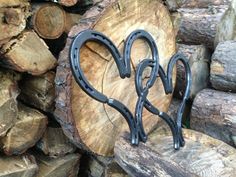 two black metal scissors sitting on top of a pile of wood