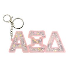 an acrylic keychain with the word aea spelled out in glitter