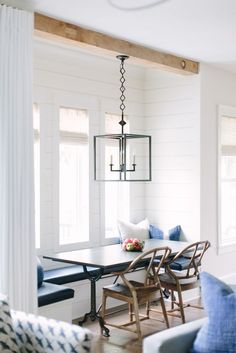 a dining room table with blue chairs and white walls