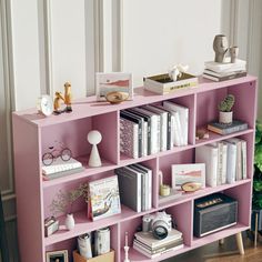 a pink book shelf filled with lots of books