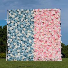 an american flag made out of flowers on top of a grass covered field with trees in the background