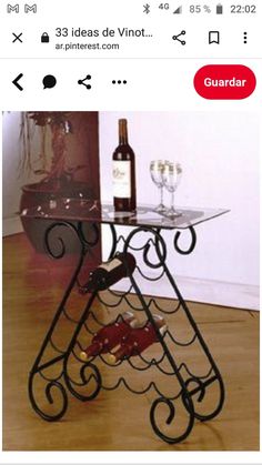 a glass table with wine bottles and two glasses on it, in front of a wall