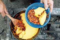 a person holding a blue bowl filled with food