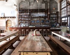 an empty restaurant with wooden tables and benches