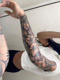 a woman with tattoos on her arm is taking a selfie in front of a mirror