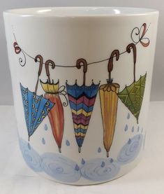 a coffee cup decorated with umbrellas hanging from a line