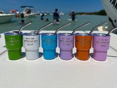 four different colored tumblers sitting on top of a boat