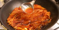 someone is cooking spaghetti in a skillet on the stove