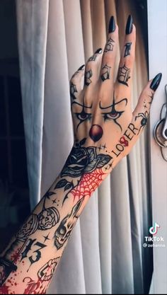 a woman's hand with tattoos on it next to a curtain and keychain